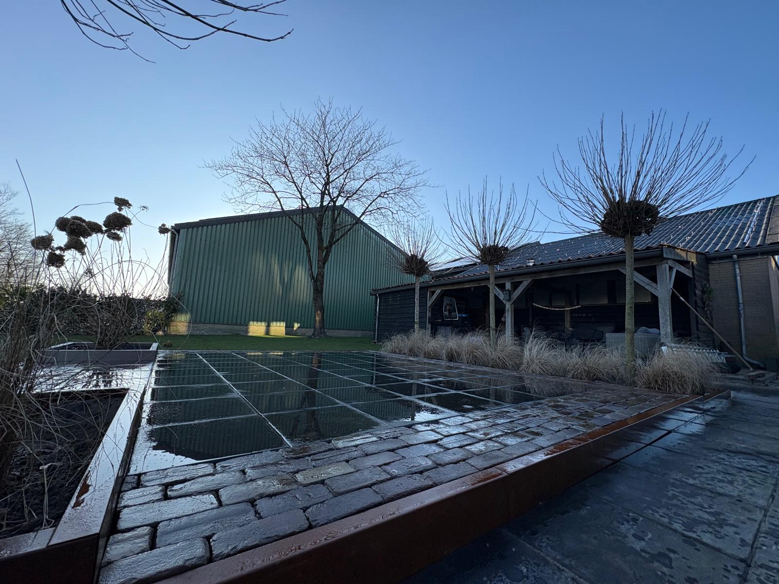 Strakke bestrating in een tuin met terras en looppad